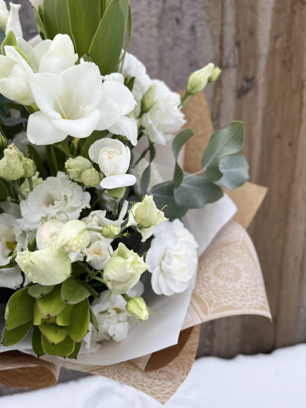 Мінімалістичний букет в білому кольорі - деталь натуральної композиції з ніжною зеленню Крупний план букета в білому кольорі - деталі білих квітів і зелені в еко-обстановці