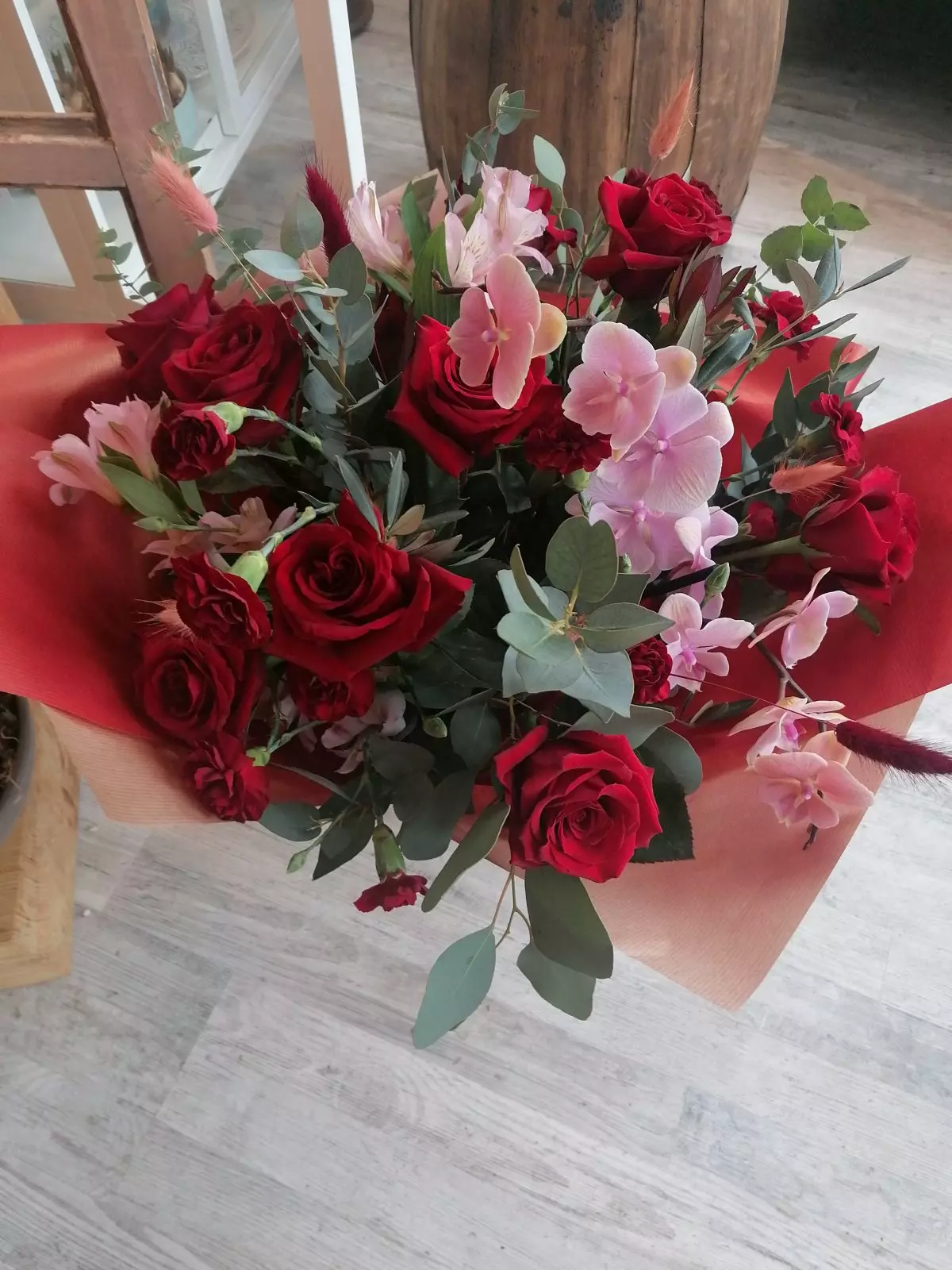 Дорогоцінні червоні троянди, орхідеї фаленопсис та пудрово-рожеві акценти створюють сучасне видання букета. Своєрідний клас!