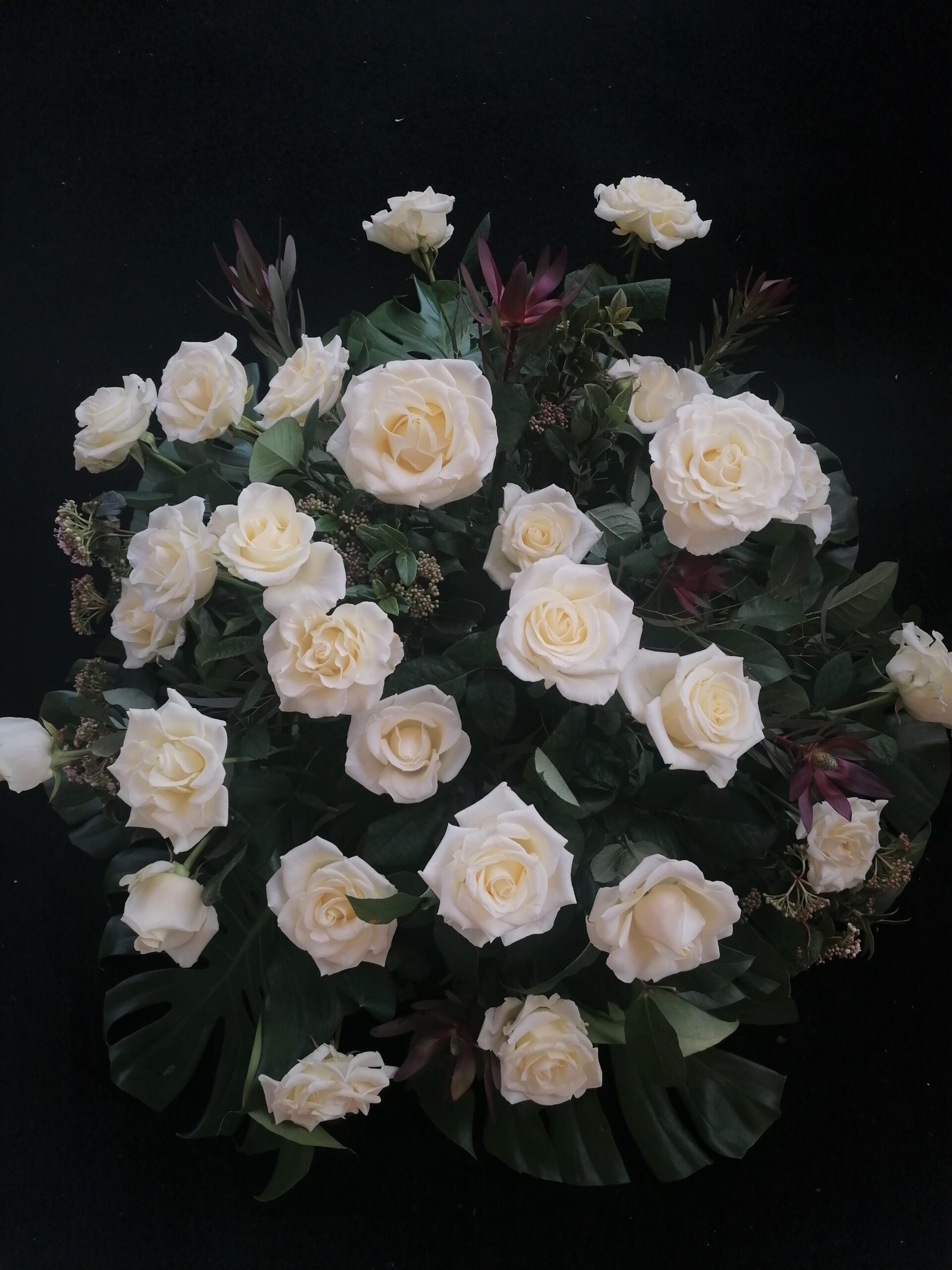 Przełamanie kolorystyczne bieli stanowi leukadendron - towarzysz róż oraz duża ilość zieleni.