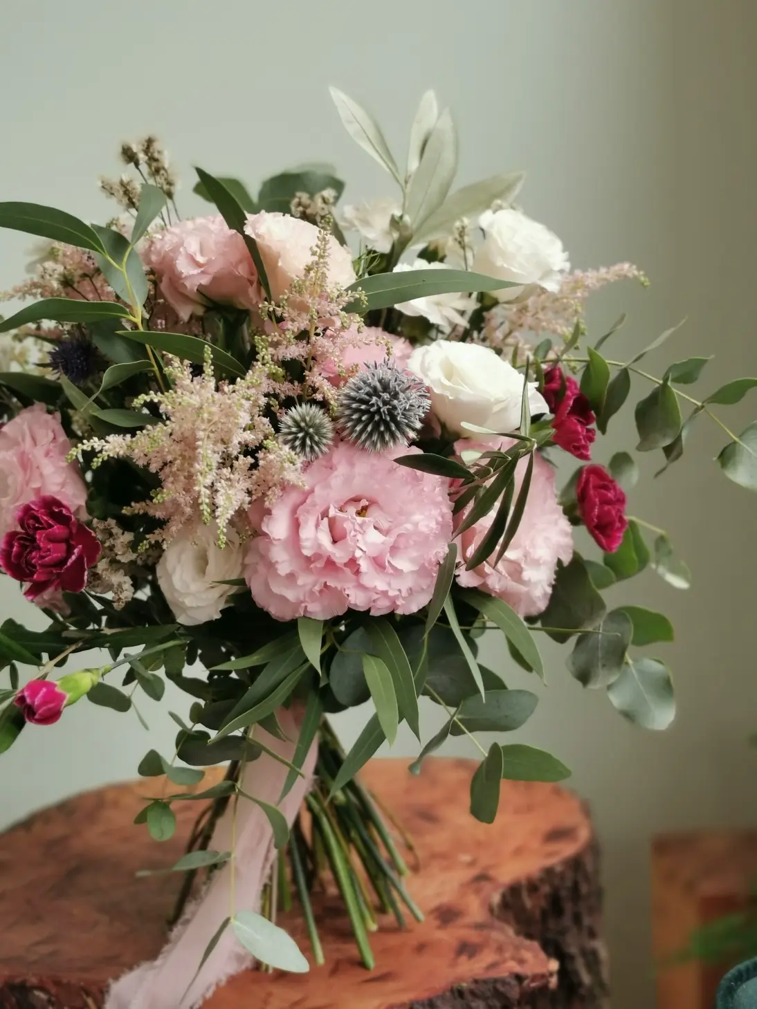 Romantic eustoms in shades of pink and white, complemented by a soaring filigree trailing sedum , navy blue scallops and a stronger carnation accent.