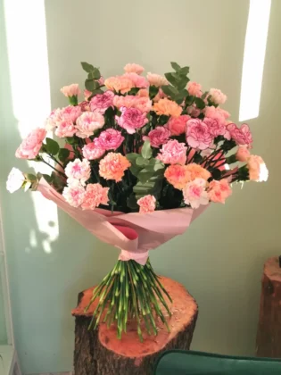 Here is a unique, stately bouquet of full carnations in subtle shades of pastel pink, peach, purple.
