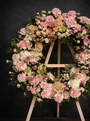Roman wreath in pastel shades with roses and carnations on a dark background
