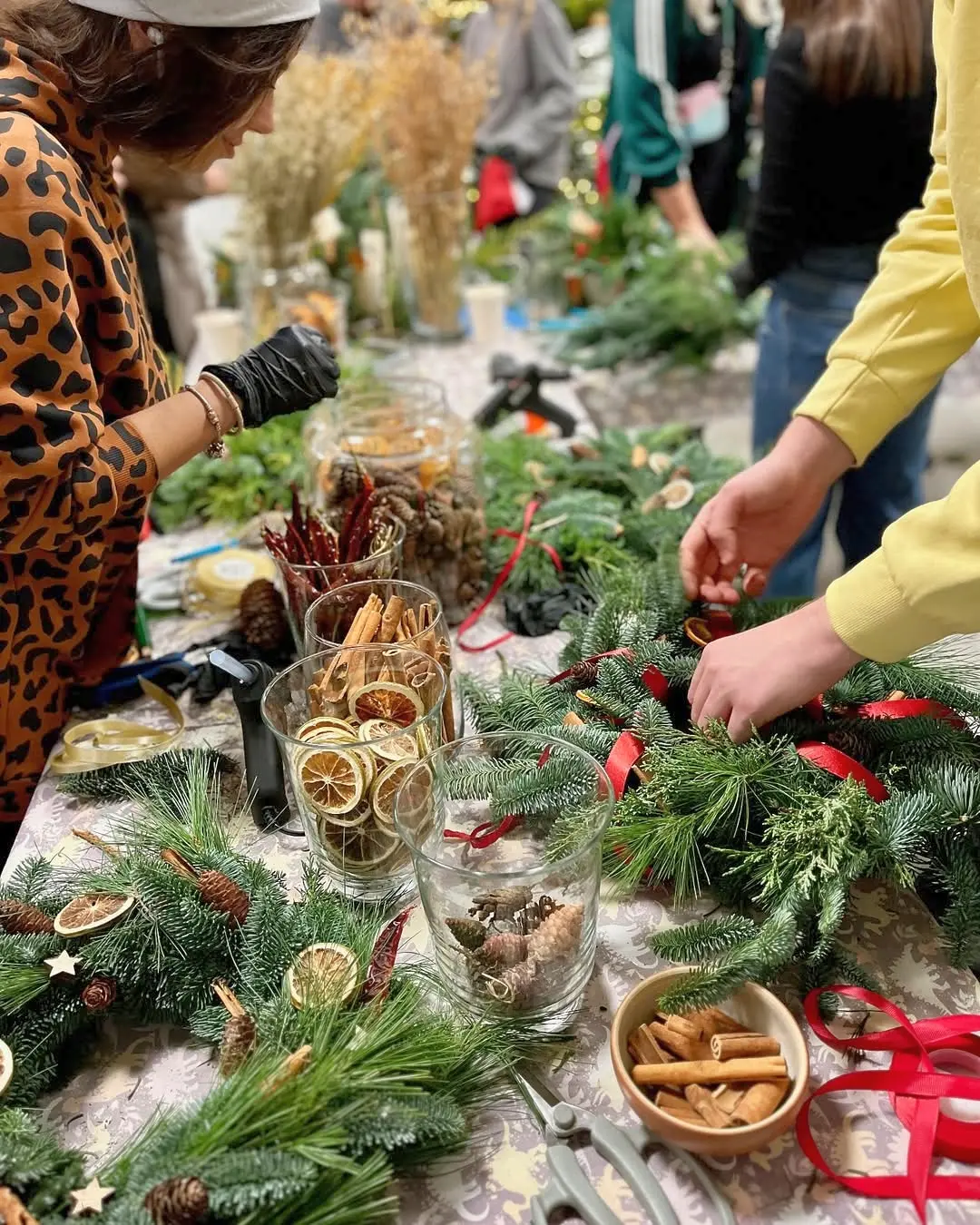 Uczestnicy świątecznych warsztatów florystycznych tworzą wianki z gałązek iglastych i suszonych ozdób – W Korcu Maku Katowice