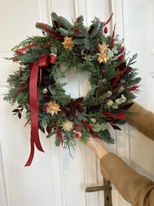Detail of maroon garland with red fruit and eucalyptus
